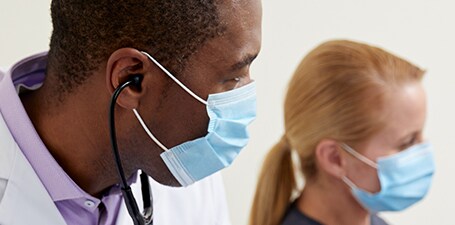 Gros plan d’un clinicien avec un stéthoscope dans les oreilles
