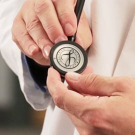 Plan rapproché d’un médecin tenant le pavillon d’un stéthoscope 3M Littmann doté du joint Littmann sur la membrane.